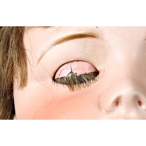 28 - A large German bisque head doll, stamped '12', with weighted dark brown eyes, real hair lashes and h... 