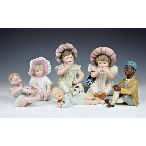 34 - A collection of early 20th century bisque piano dolls, comprising a pair of large infant girls, the ... 