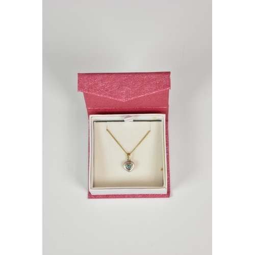 920 - A 9ct two colour gold and topaz heart shaped pendant, on a 9ct yellow gold curb link chain.