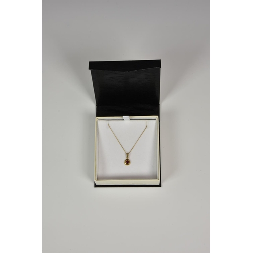 927 - A 9ct gold and ruby teardrop pendant, on a 9ct gold 16in. curb link chain.