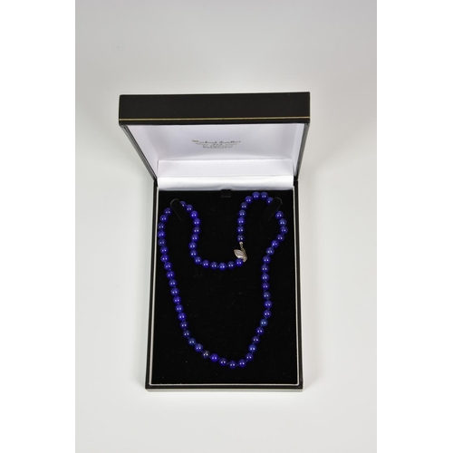 930 - A 17½in. lapis lazuli bead necklace, with silver clasp.