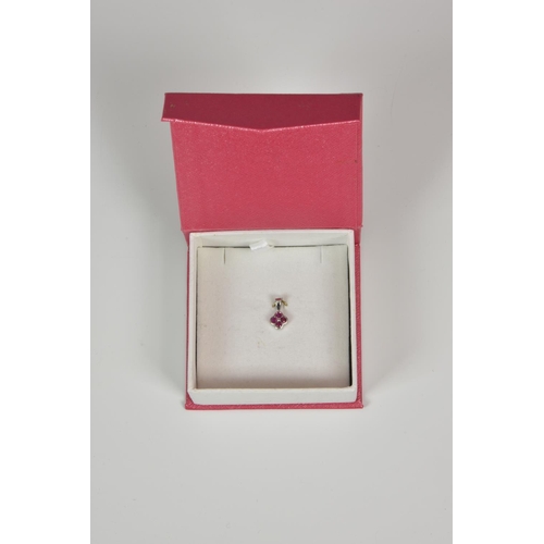 939 - A 9ct white gold and ruby floral pendant,