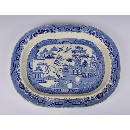 122 - A large 19th century willow pattern meat platter, stamped 'EVANS & CLASSIN - SWANSEA', 22 5/8in. (57... 