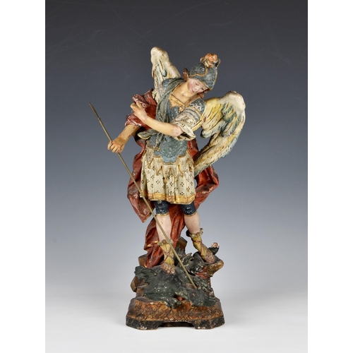 17 - A 19th century painted and gilded terracotta figure of St Michael the Archangel slaying the Dragon, ... 