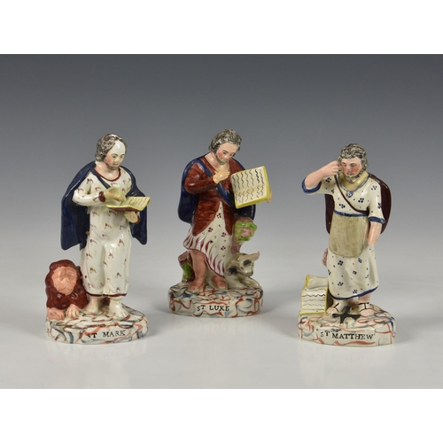 22 - Three early 19th century pearlware Staffordshire figures of saints, depicting St. Mark, St. Luke and... 