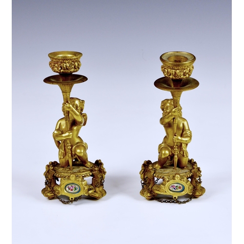 2866 - A pair of French cast bronze ormolu figural candlesticks, in the form of putti holding aloft rococo ... 