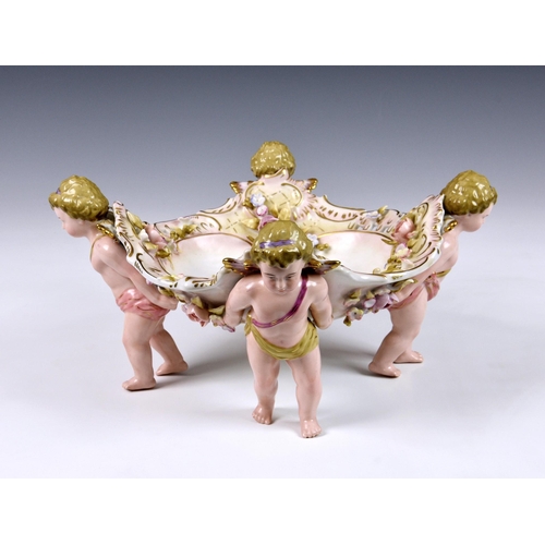 65 - A German Schierholz porcelain figural compote or table centrepiece, the shaped bowl, with pierced ri... 