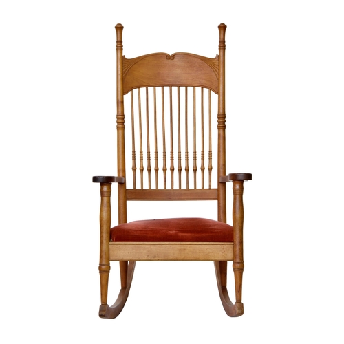 786 - An Art Nouveau style beechwood rocking chair, early 20th century, the spindle back with deep, cornuc... 