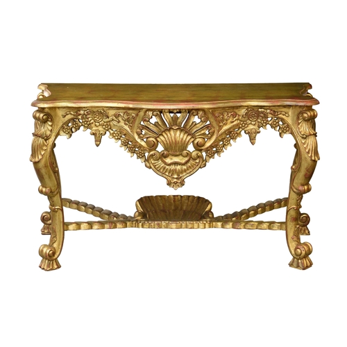 831 - A large George I style giltwood console table, the serpentine moulded top over a bold pierced and ca... 