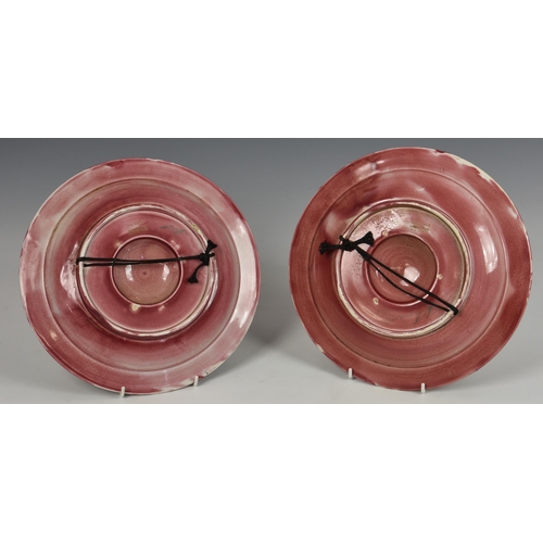 43 - A pair of Moorcroft / Liberty flamminian ware alms dish wall plaques, in pink / red glaze, of typica... 