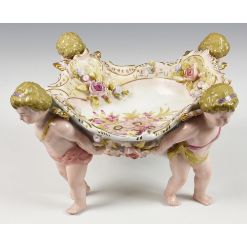 65 - A German Schierholz porcelain figural compote or table centrepiece, the shaped bowl, with pierced ri... 