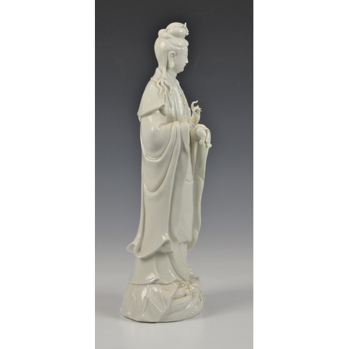 68 - A Blanc de Chine figure of Guanyin, Continental, 20th century, figure holding a vase, standing on lo... 