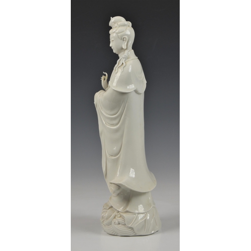 68 - A Blanc de Chine figure of Guanyin, Continental, 20th century, figure holding a vase, standing on lo... 