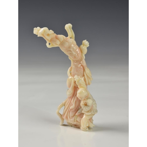 1487 - A Chinese carved angel skin coral figure, 20th century, depicting a female deity in flowing robes wi... 