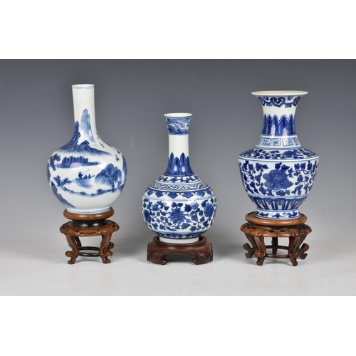 1516 - Three Chinese blue and white porcelain vases, 20th century, one of bottle form, painted with a mount... 