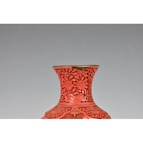 1533 - A Chinese cinnabar lacquer vase, early 20th century, baluster form, carved with figures and building... 