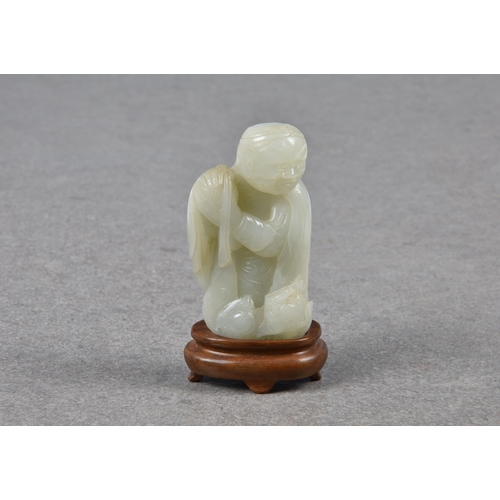 1555 - A Chinese pale celadon carving of an elderly man and fo dog, probably Qing dynasty, the robed man we... 