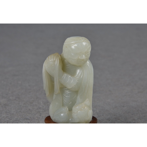 1555 - A Chinese pale celadon carving of an elderly man and fo dog, probably Qing dynasty, the robed man we... 