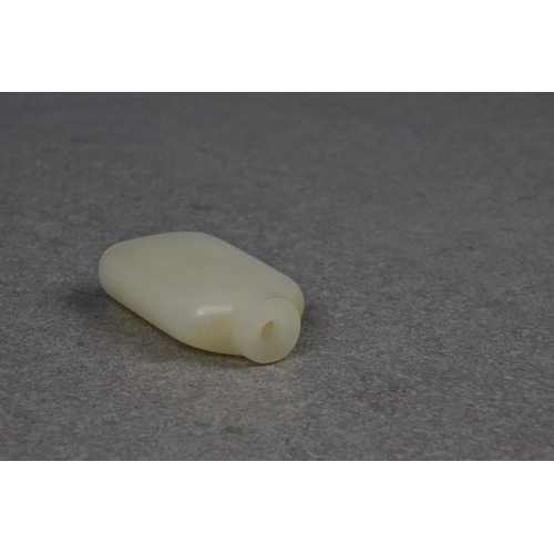 1557 - A Chinese celadon jade snuff bottle, of rectangular form with rounded shoulders and shallow, slightl... 