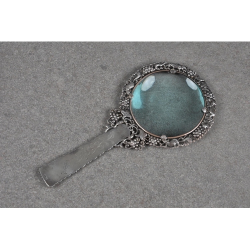 1563 - A Chinese silver and celadon jade magnifying glass, early 20th century, the lens within a pierced si... 