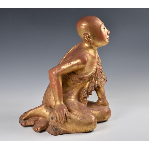 1592 - A Burmese Mandalay carved, lacquered and jewelled gilt wood figure of a seated monk, probably late 1... 