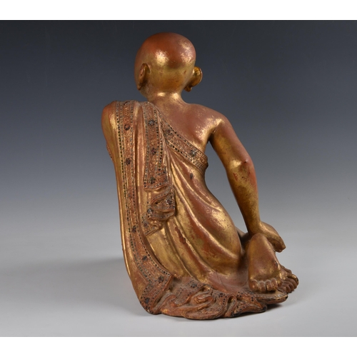 1592 - A Burmese Mandalay carved, lacquered and jewelled gilt wood figure of a seated monk, probably late 1... 