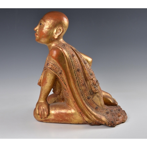 1592 - A Burmese Mandalay carved, lacquered and jewelled gilt wood figure of a seated monk, probably late 1... 