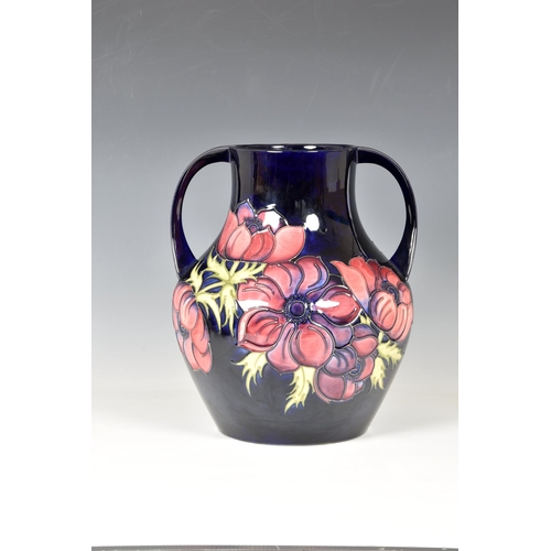 16 - A large Moorcroft twin handled Pottery vase, Walter Moorcroft,  'anemone' pattern on dark blue groun... 