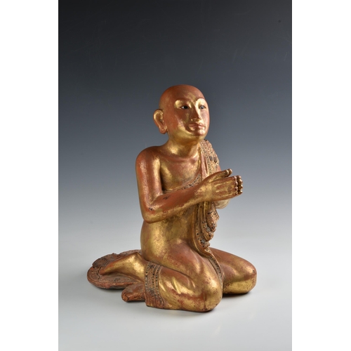 1622 - A Burmese Mandalay carved and jewelled gilt wood figure of a seated monk, probably late 19th century... 