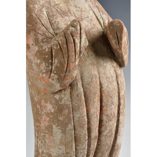 1623 - A Chinese Tang Dynasty (AD 618-906) pottery figure of a Court Lady, modelled standing with her body ... 