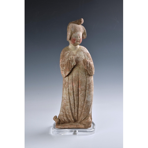 1623 - A Chinese Tang Dynasty (AD 618-906) pottery figure of a Court Lady, modelled standing with her body ... 