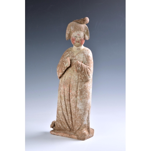 1623 - A Chinese Tang Dynasty (AD 618-906) pottery figure of a Court Lady, modelled standing with her body ... 