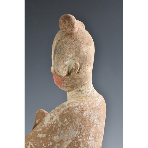 1623 - A Chinese Tang Dynasty (AD 618-906) pottery figure of a Court Lady, modelled standing with her body ... 