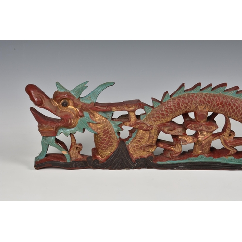 1632 - A Chinese polychrome painted and parcel gilt carved wooden dragon panel, probably early 20th century... 