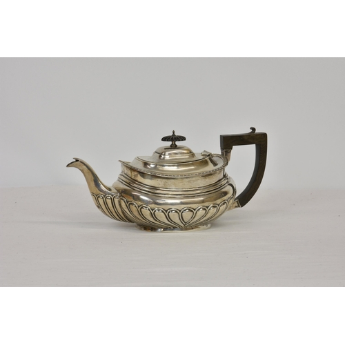 199 - An Edwardian silver teapot, William Aitken, Birmingham 1905, of oval bellied form with ebony handle ... 