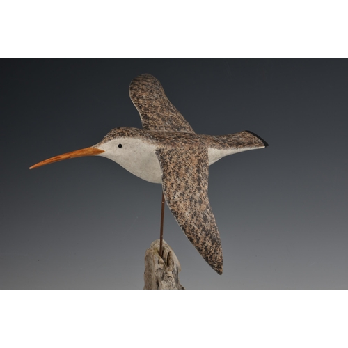 2078 - A decoy style carved and painted wooden sculpture of a curlew in flight, on a driftwood stand with s... 