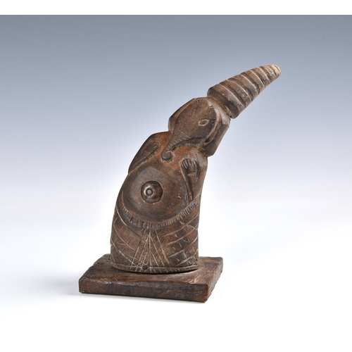 2096 - Tribal art - A carved horn figure of a dancer in an elephant mask, with brass coin button to the bel... 