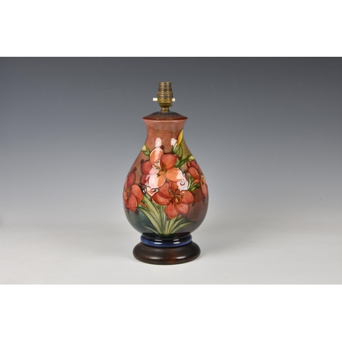 27 - A Moorcroft flambe glazed lamp, baluster form, in the Fresia pattern on a rust red and blue flambe g... 