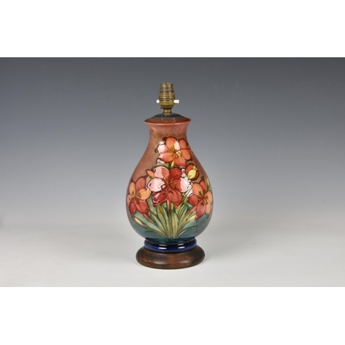 27 - A Moorcroft flambe glazed lamp, baluster form, in the Fresia pattern on a rust red and blue flambe g... 