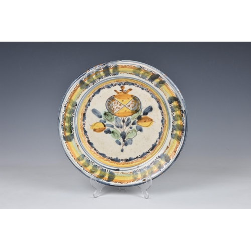 30 - An Italian maiolica polychrome charger, 18th century, painted with a pomegranate within blue, auberg... 