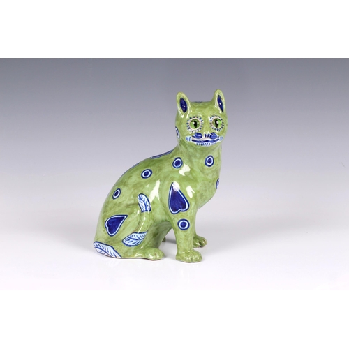 60 - A German Galle type Mosanic pottery model of a seated cat, painted in lime green with naive blue h... 