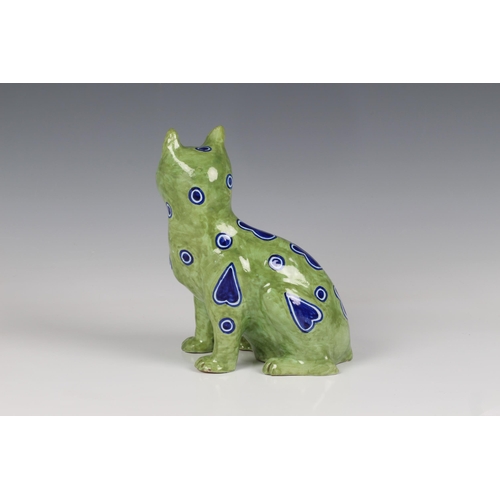 60 - A German Galle type Mosanic pottery model of a seated cat, painted in lime green with naive blue h... 