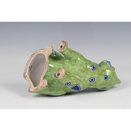 60 - A German Galle type Mosanic pottery model of a seated cat, painted in lime green with naive blue h... 