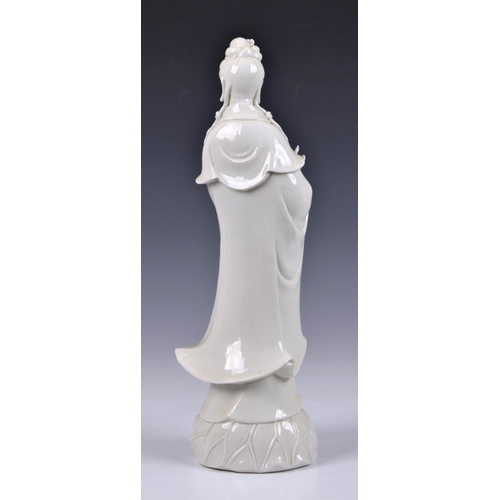 66 - A Blanc de Chine figure of Guanyin, Continental, 20th century, figure holding a vase, standing on lo... 