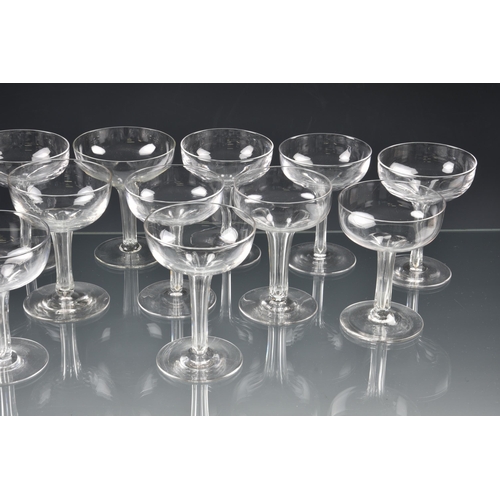 73 - *** WITHDRAWN *** A well matched set of fourteen Edwardian hollow stem champagne saucers, the drawn,... 