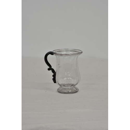 84 - A Georgian blown glass tankard, with dark coloured handle and flared rim, pronounced pontil, 4in. (1... 