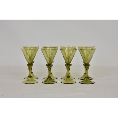 86 - A set of eight Continental green wine glasses, mid-20th century, with rounded spiral design funnel b... 