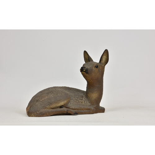 52 - A ceramic figure of a fawn, unglazed, unmarked, 11½in. (29.2cm.) high, 15in. (38.1cm.) wide.. *