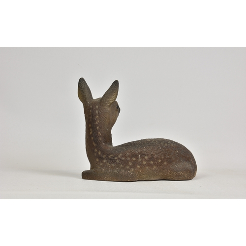 52 - A ceramic figure of a fawn, unglazed, unmarked, 11½in. (29.2cm.) high, 15in. (38.1cm.) wide.. *