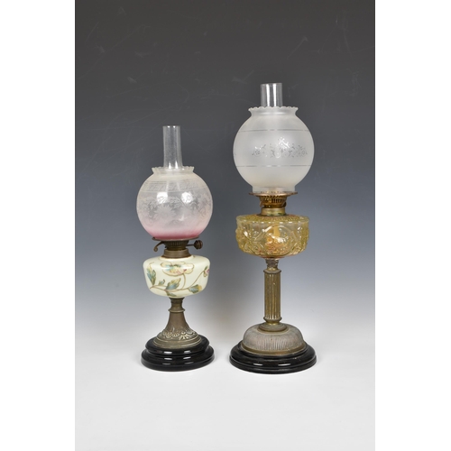 2133 - Two antique oil lamps, the first with bronze coloured moulded glass reservoir, depicting scrolls and... 